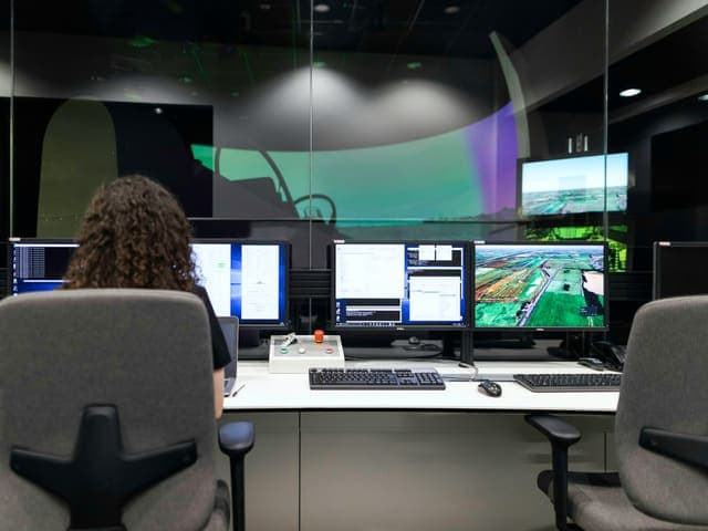 Dispatcher at a multi-screen operations desk
