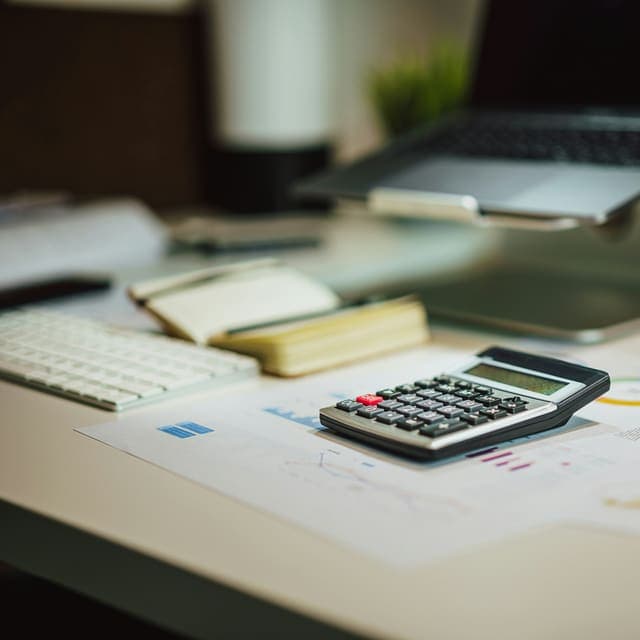Back-office desk with calculator and reports